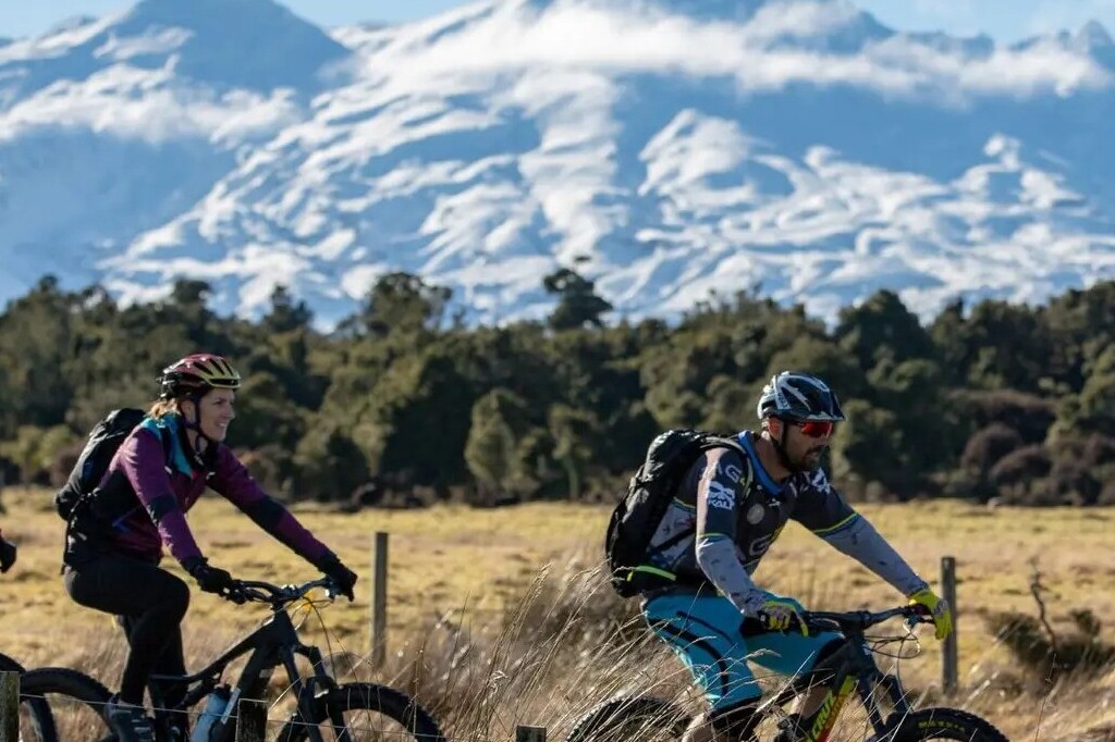 A mountain biker on a trail with mountains in the background